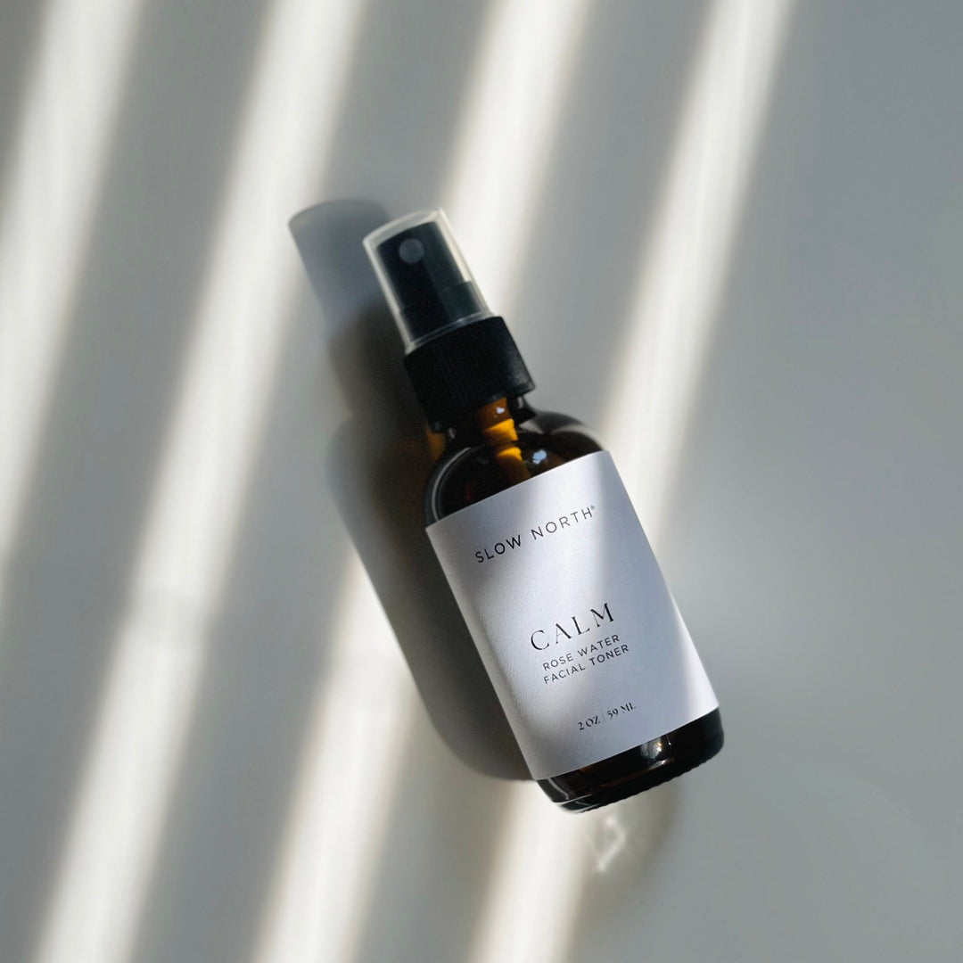 Rose water facial toner with white label and rose illustrations on a neutral background.