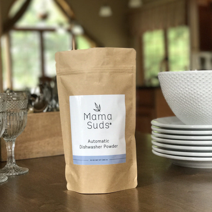 Natural, PVA-free dishwasher powder in a resealable bag with a measuring scoop.