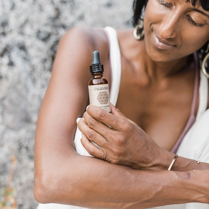 Ayurvedic sesame and lavender ear oil in a glass dropper bottle with herbs.