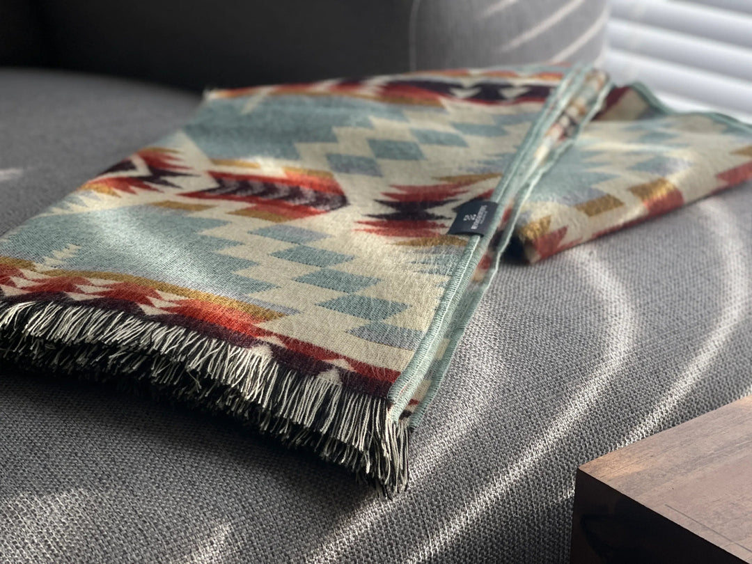 Vibrant Mint fringed Andean throw with a sage, teal, and rust geometric pattern.