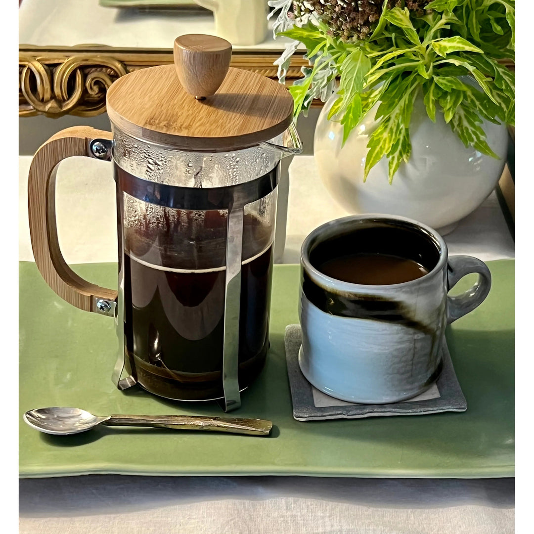 Bamboo French press with a glass carafe and bamboo handle for brewing coffee.