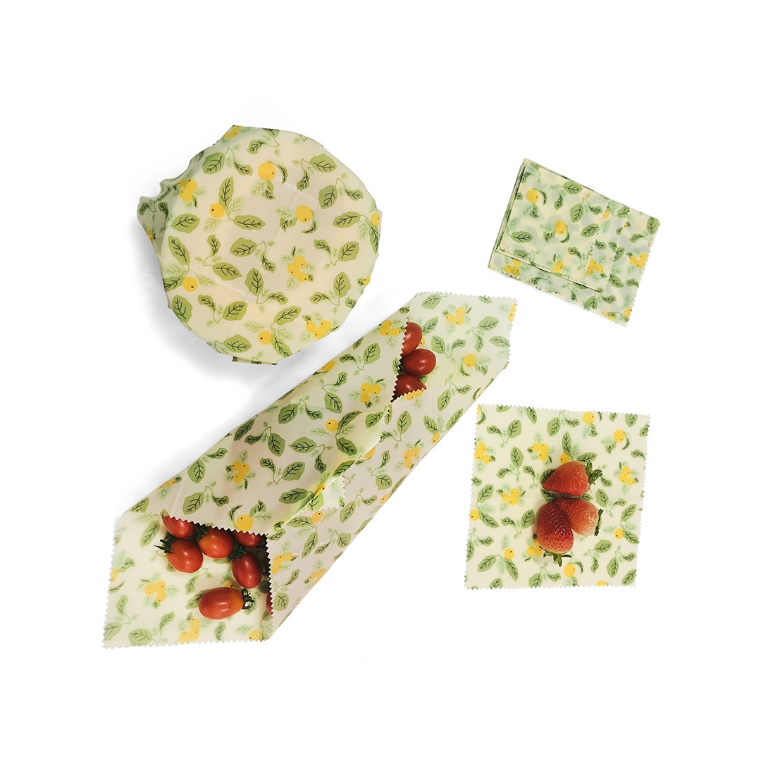 Set of three beeswax food wraps in various sizes with colorful patterns for food storage.