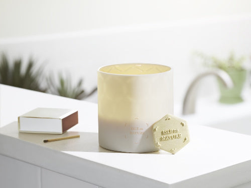 Beeswax candle with a Caribbean-inspired design, set against a natural background.