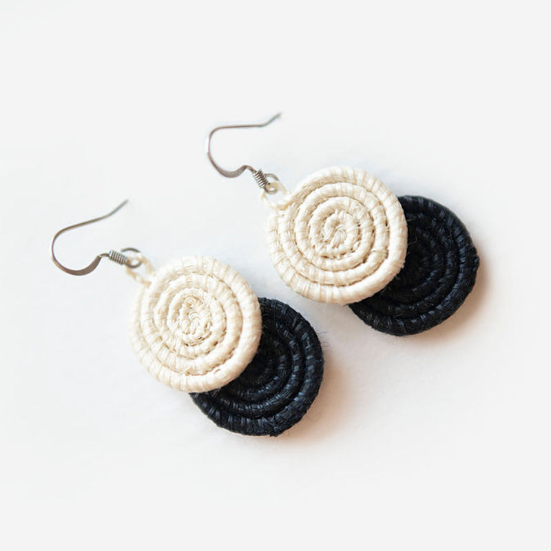 Black woven disc earrings made from sisal fiber with a circular design.