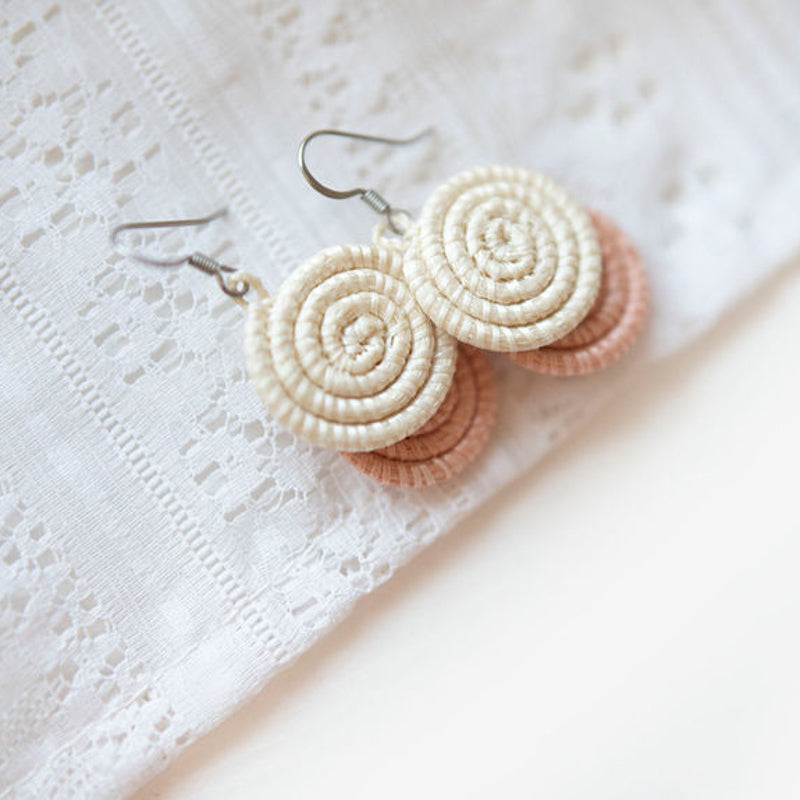 Handcrafted woven disc earrings in blush sisal fiber.