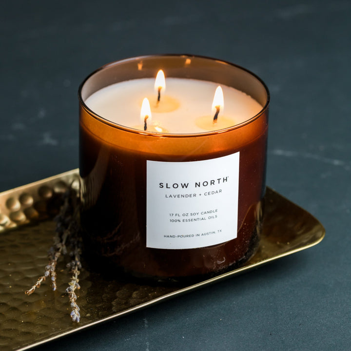 Lavender Cedar three-wick candle in a clear glass jar with minimalist label.