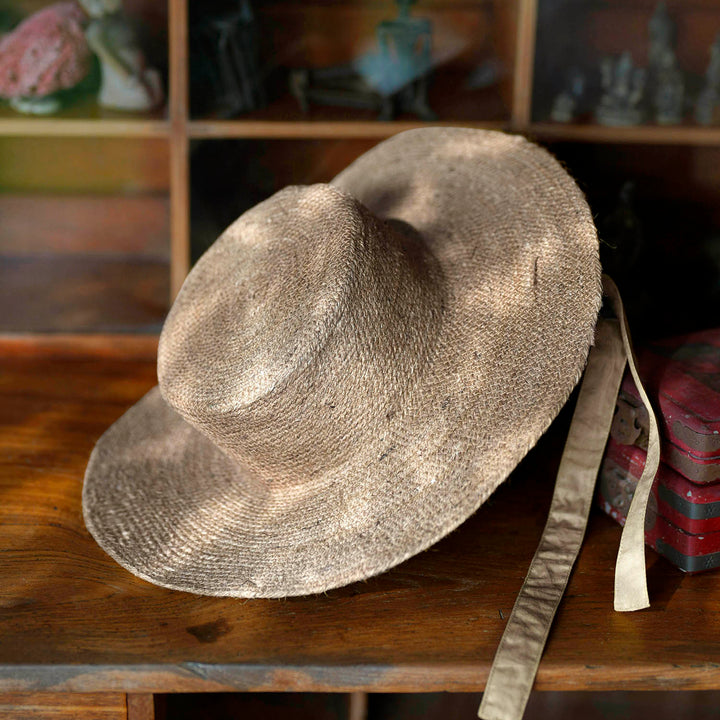 Neutral beige jute straw hat with a wide brim and casual style, perfect for sunny outdoor wear.