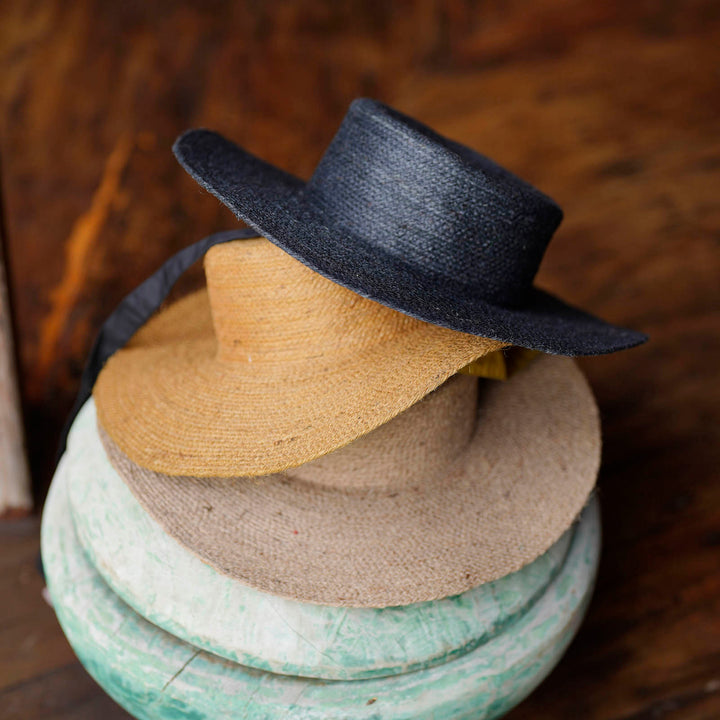 Neutral beige jute straw hat with a wide brim and casual style, perfect for sun coverage and summer wear.