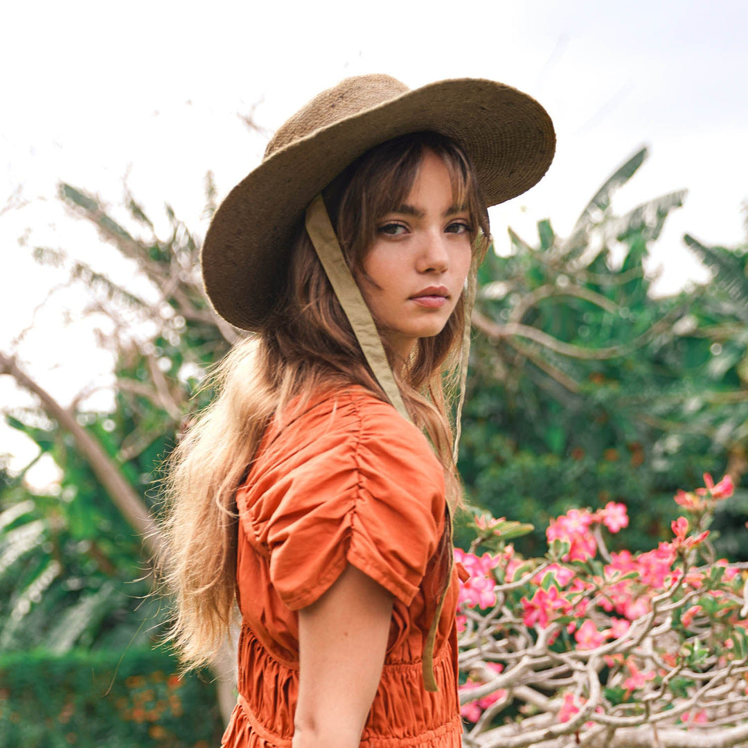 Neutral beige jute straw hat with a wide brim and casual style, perfect for sunny outdoor wear.