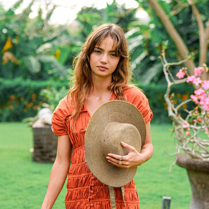Neutral beige jute straw hat with a wide brim and woven texture, perfect for summer outdoor wear.