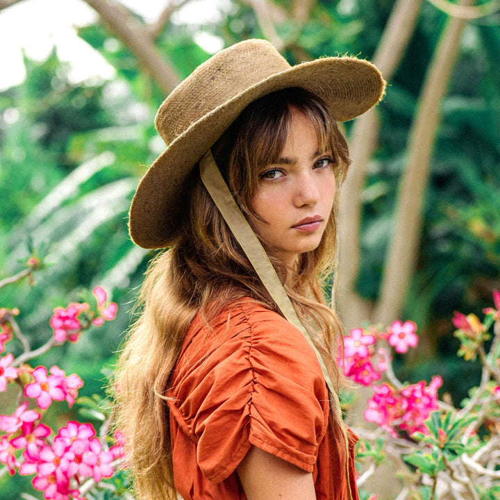 Neutral beige jute straw hat with a wide brim and woven texture, stylish and lightweight for sun coverage.