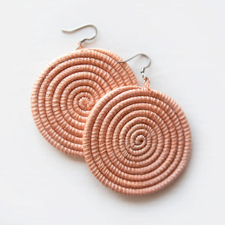 Large woven disc earrings in blush color, featuring intricate weaving on a white background, by DC-Azizi Life Inc.