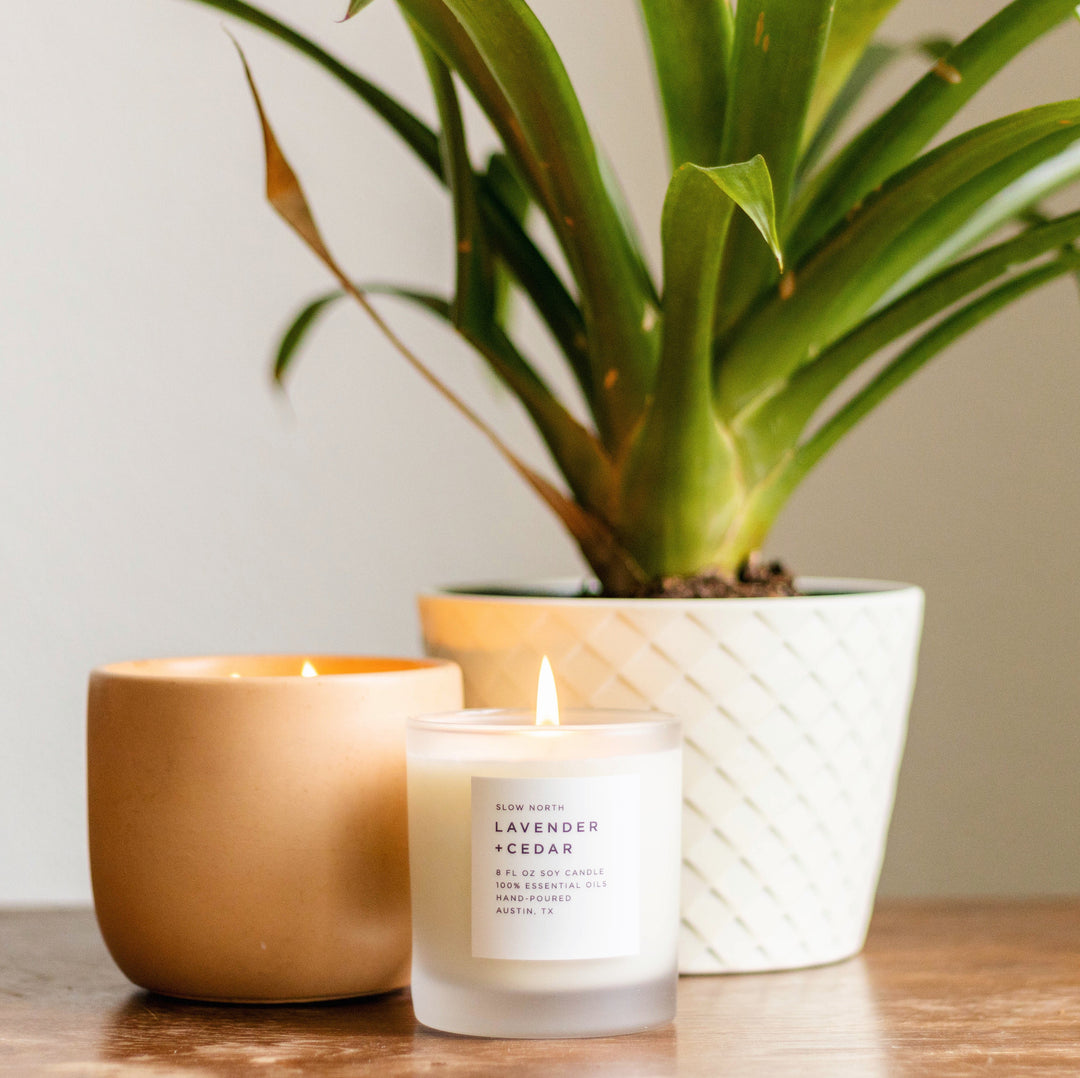 Lavender and cedar signature candle in an 8 oz glass jar with a lit wick.