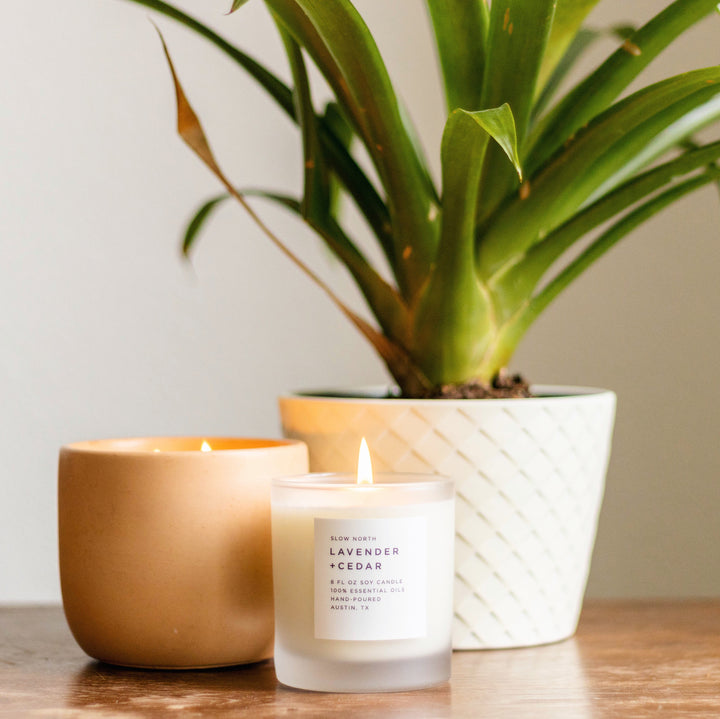 Lavender and cedar signature candle in an 8 oz glass jar with a lit wick.