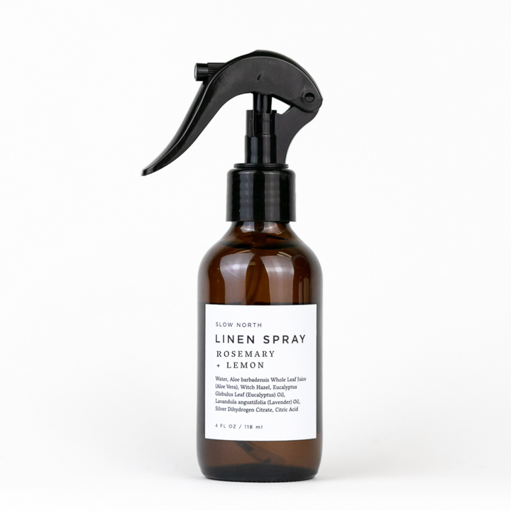 Rosemary lemon linen spray in a glass spray bottle with botanical styling.