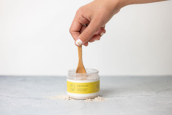 Clay facial mask with a smooth surface and herbal accents.