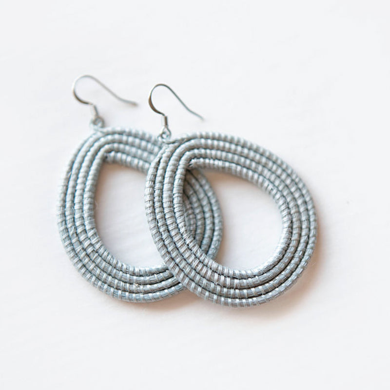 Ice blue woven loop earrings made from natural sisal on a white background.
