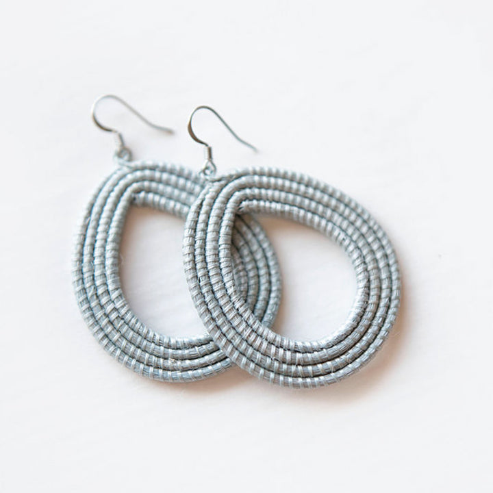 Ice blue woven loop earrings made from natural sisal on a white background.