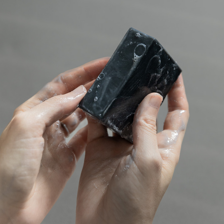 Cold-process charcoal bar soap with branded label.