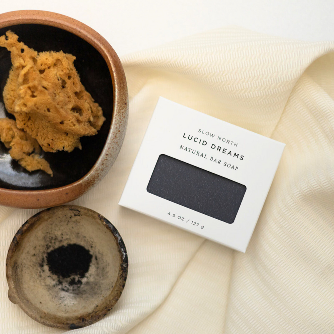 Black bar soap with charcoal and minimalist packaging design.