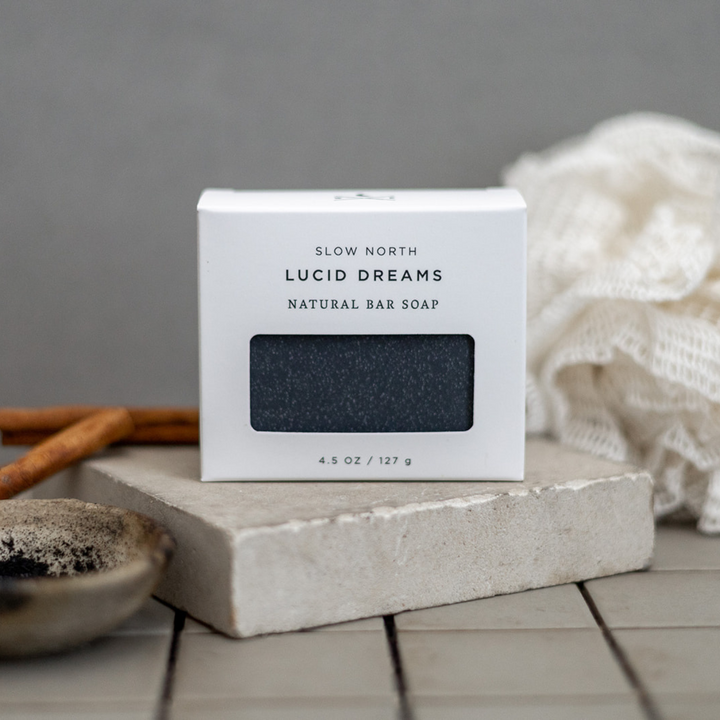 Bar soap with activated charcoal shown in simple kraft paper packaging with the Lucid Dreams label.