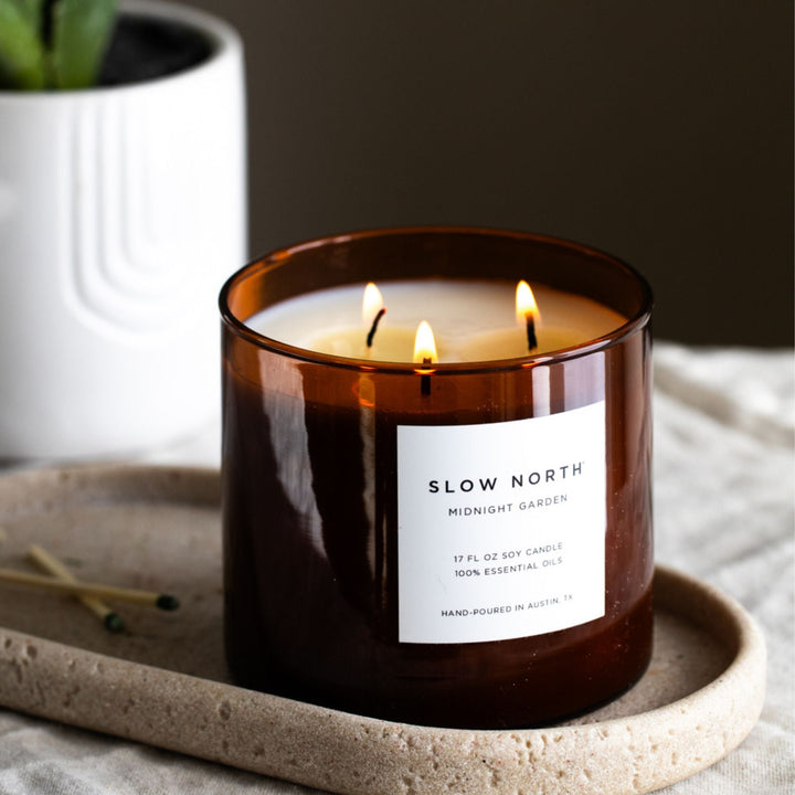 Midnight Garden three-wick candle in a decorative glass jar with three wicks.