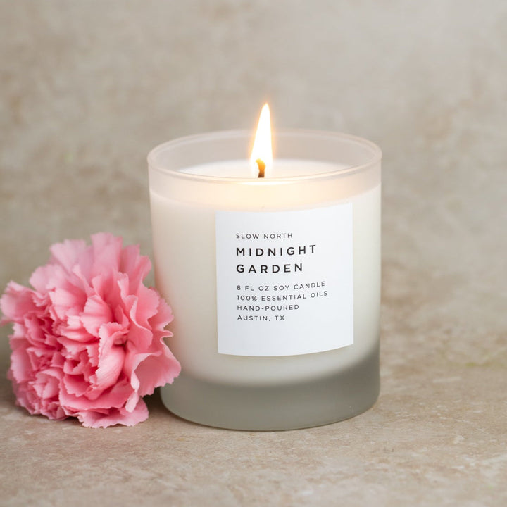 Midnight Garden signature candle with black and gold packaging and floral design.