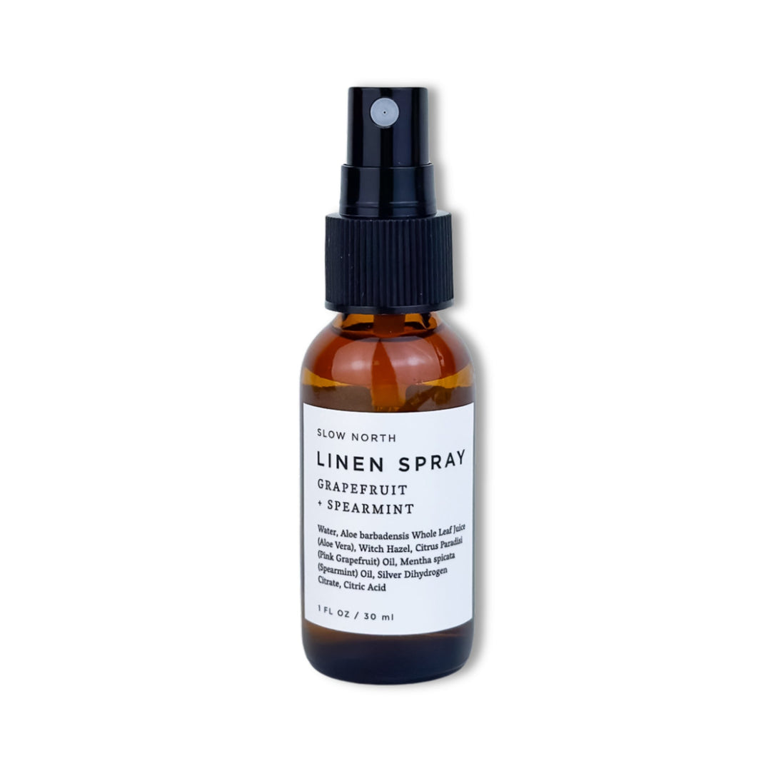 Travel-size grapefruit spearmint linen spray in a compact glass bottle.