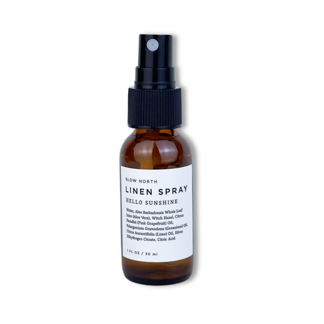 Hello Sunshine travel-size linen spray in a small glass bottle with spray nozzle.