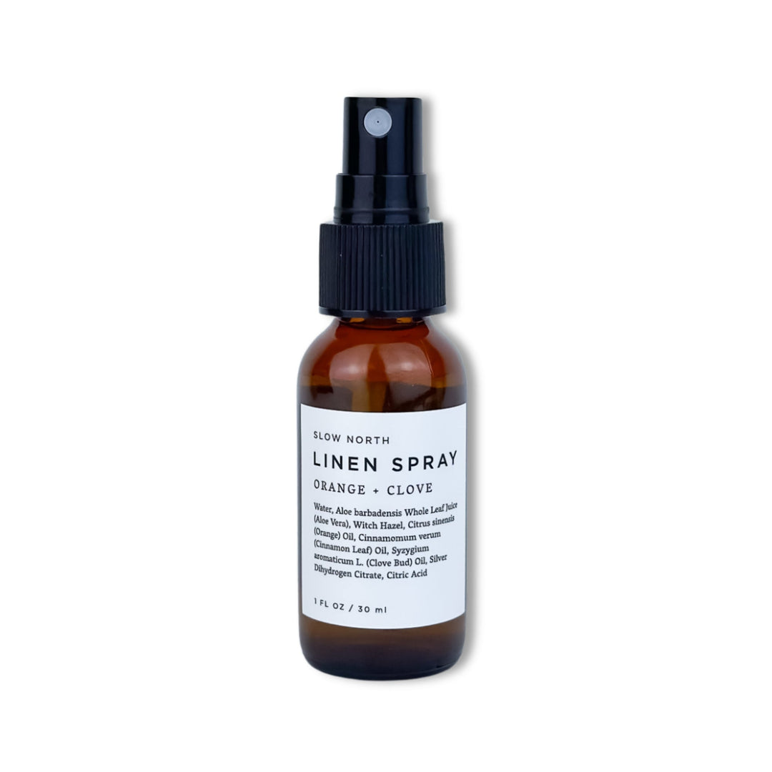 Travel-size orange clove linen spray with bright orange and clove label.