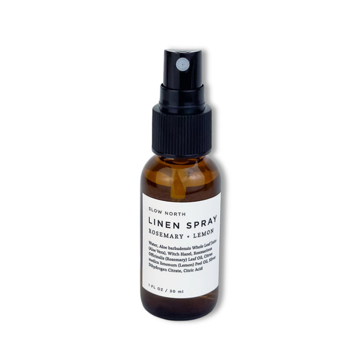 Travel-size rosemary lemon linen spray in a compact glass bottle with spray nozzle.