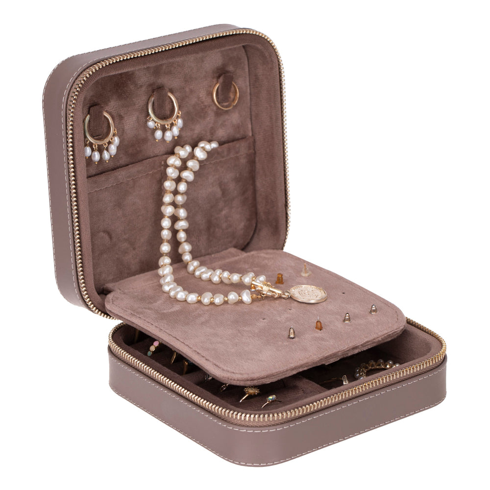 Handcrafted leather jewelry box with compartments for rings, necklaces, and earrings.