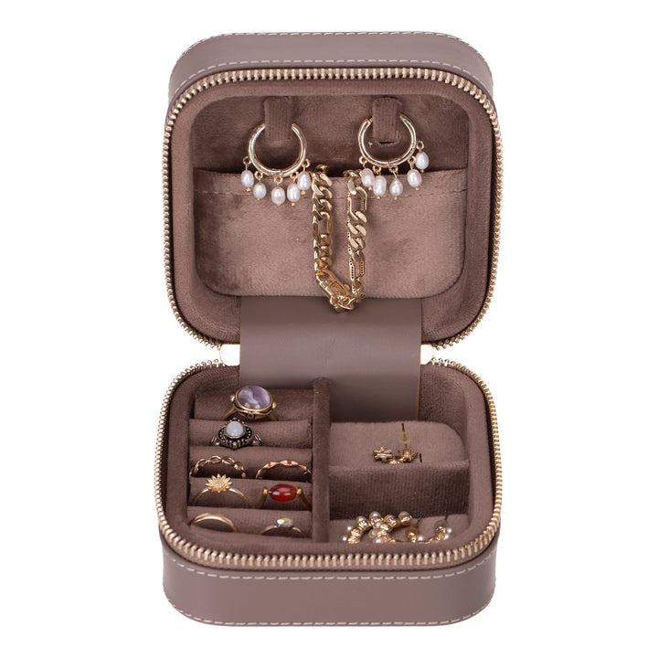 Handcrafted leather jewelry box with multiple compartments and a sleek design.