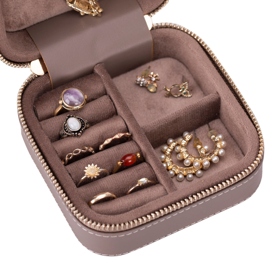 Handcrafted leather jewelry box with compartments for rings, necklaces, and bracelets.