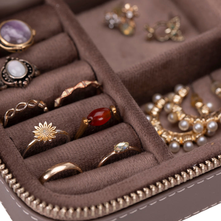 Handcrafted leather jewelry box with compartments for rings, necklaces, and bracelets.