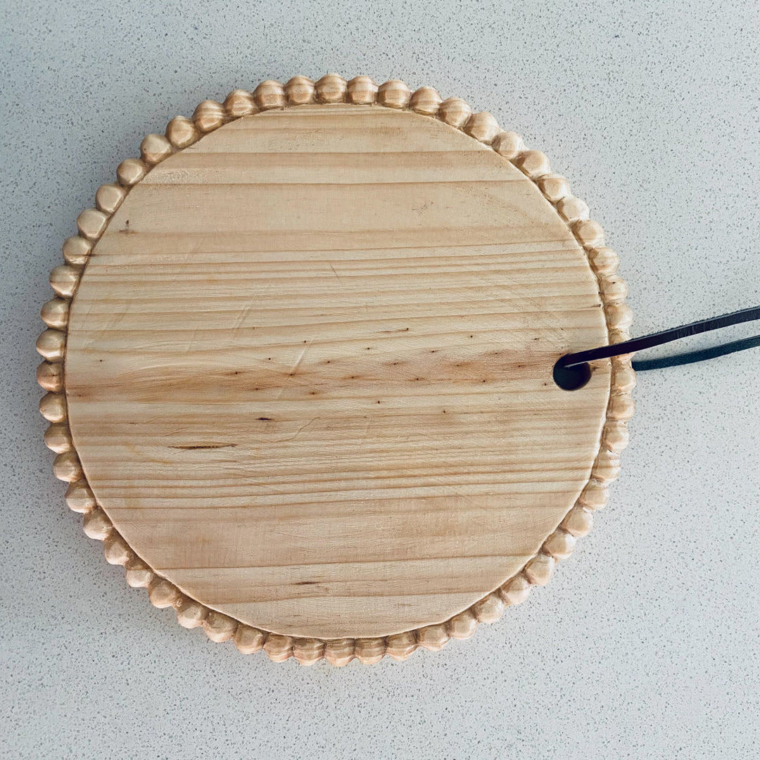 Hand-carved round mini serving board in pine wood with a smooth natural finish.