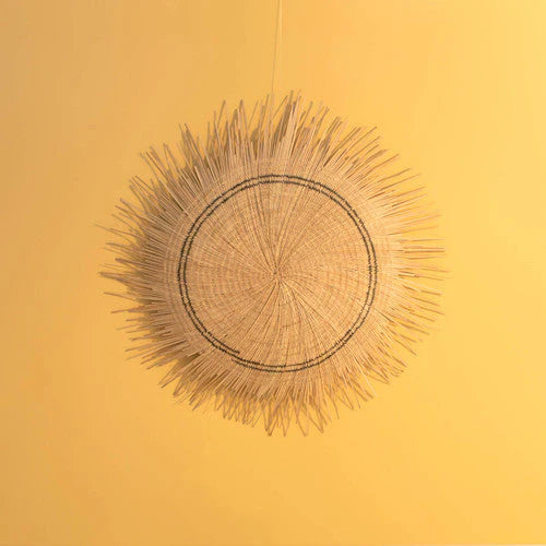 Round woven sun circle wall medallion in natural fiber for wall decor.
