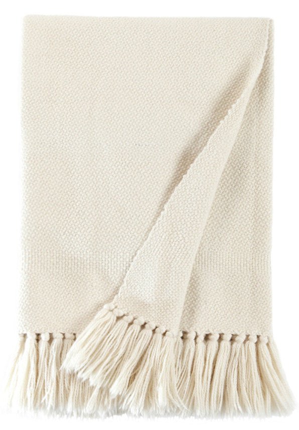 Ivory handwoven wool throw folded flat, showing the twill weave and knotted fringe.