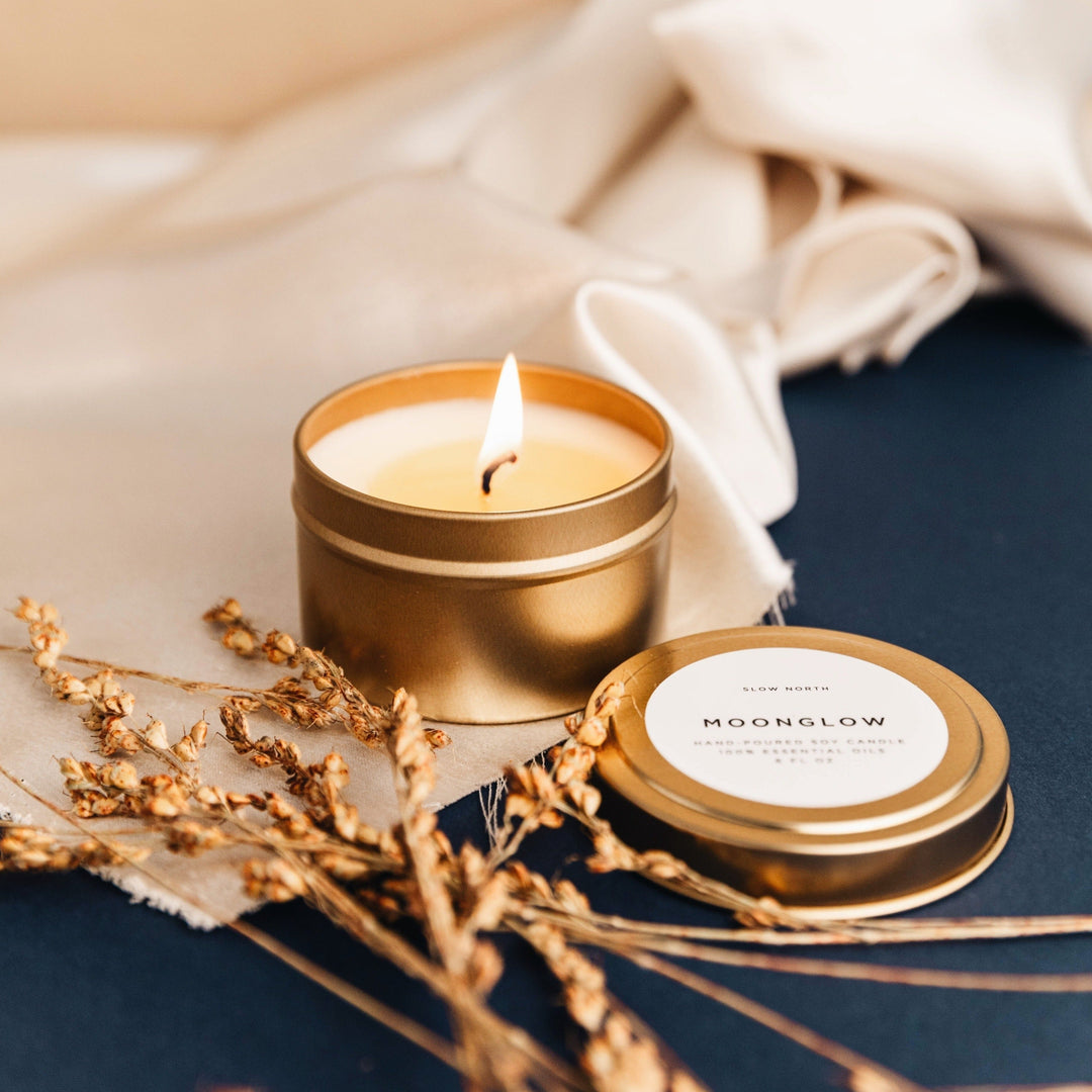 Moonglow soy candle in a brushed gold travel tin with warm earthy scent.
