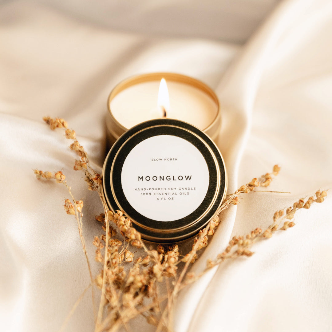 Moonglow travel tin candle with patchouli and cinnamon scent and warm glow.