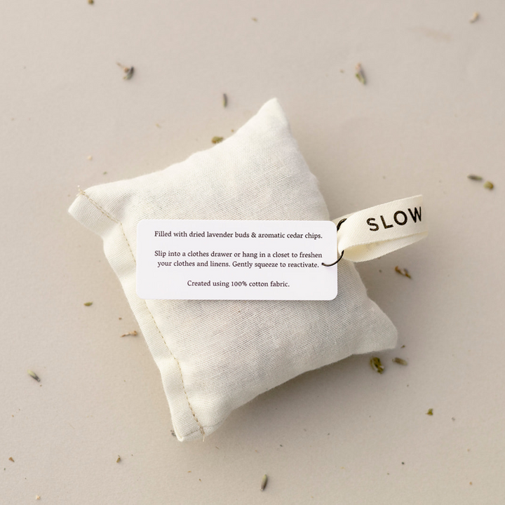 Natural cotton sachet pouch filled with lavender and cedar on a wooden surface.