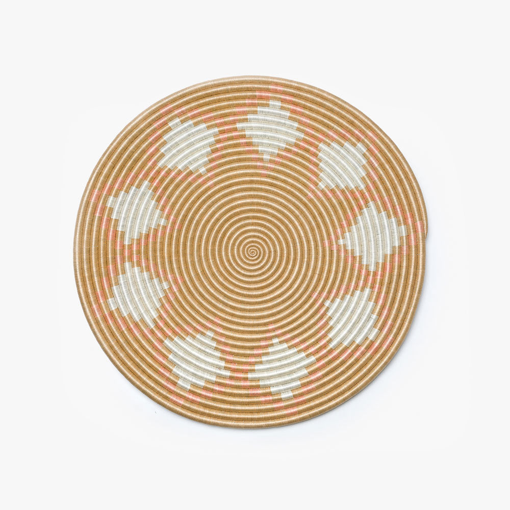 Large blush Neri flat woven sisal wall hanging with a circular radiating design.