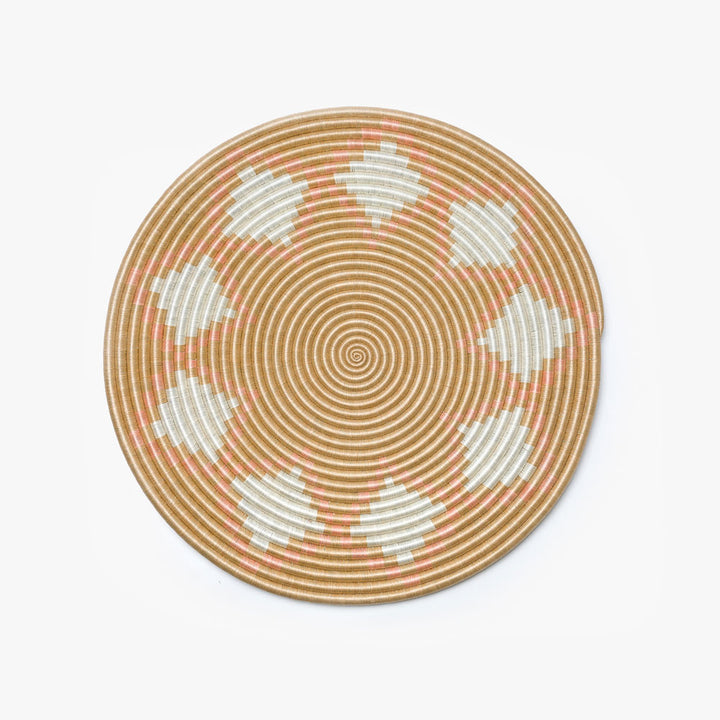 Large blush Neri flat woven sisal wall hanging with a circular radiating design.