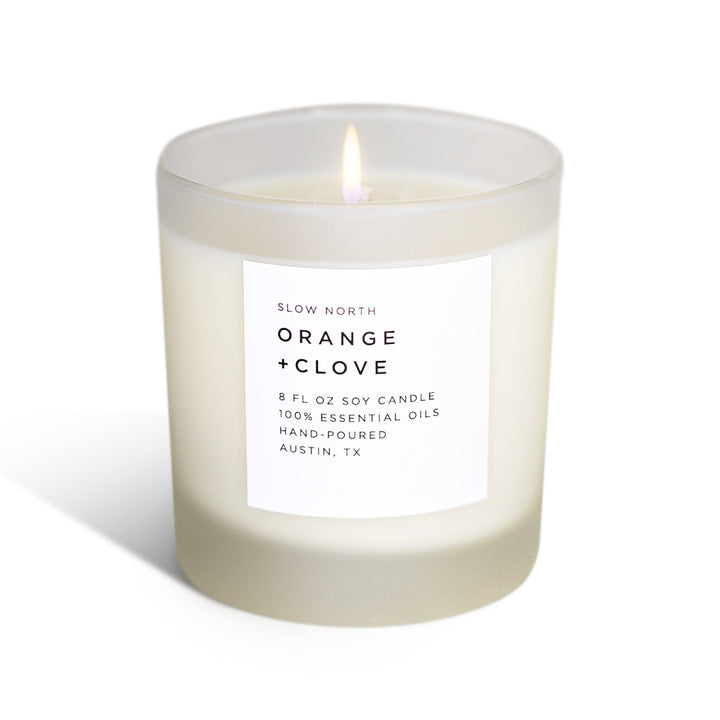 Orange Clove signature candle in a clear glass jar with warm-toned wax.