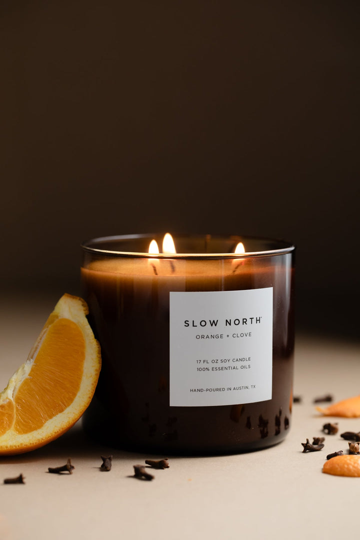 Orange Clove three-wick candle with vibrant orange wax and three wicks.