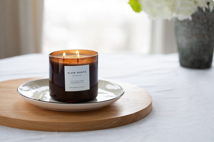 Of The Sea three-wick candle with lit flames and ocean-inspired scent.