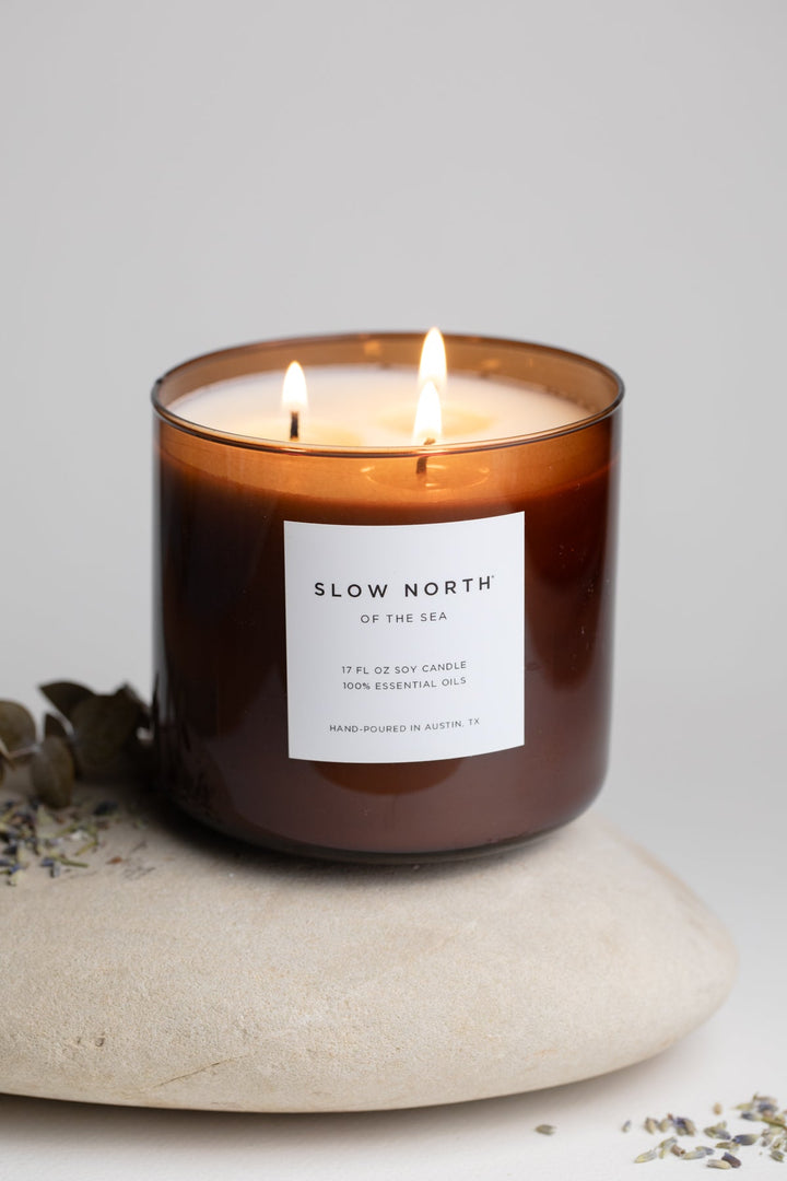 Of The Sea three-wick candle with ocean-inspired design and soft glow.