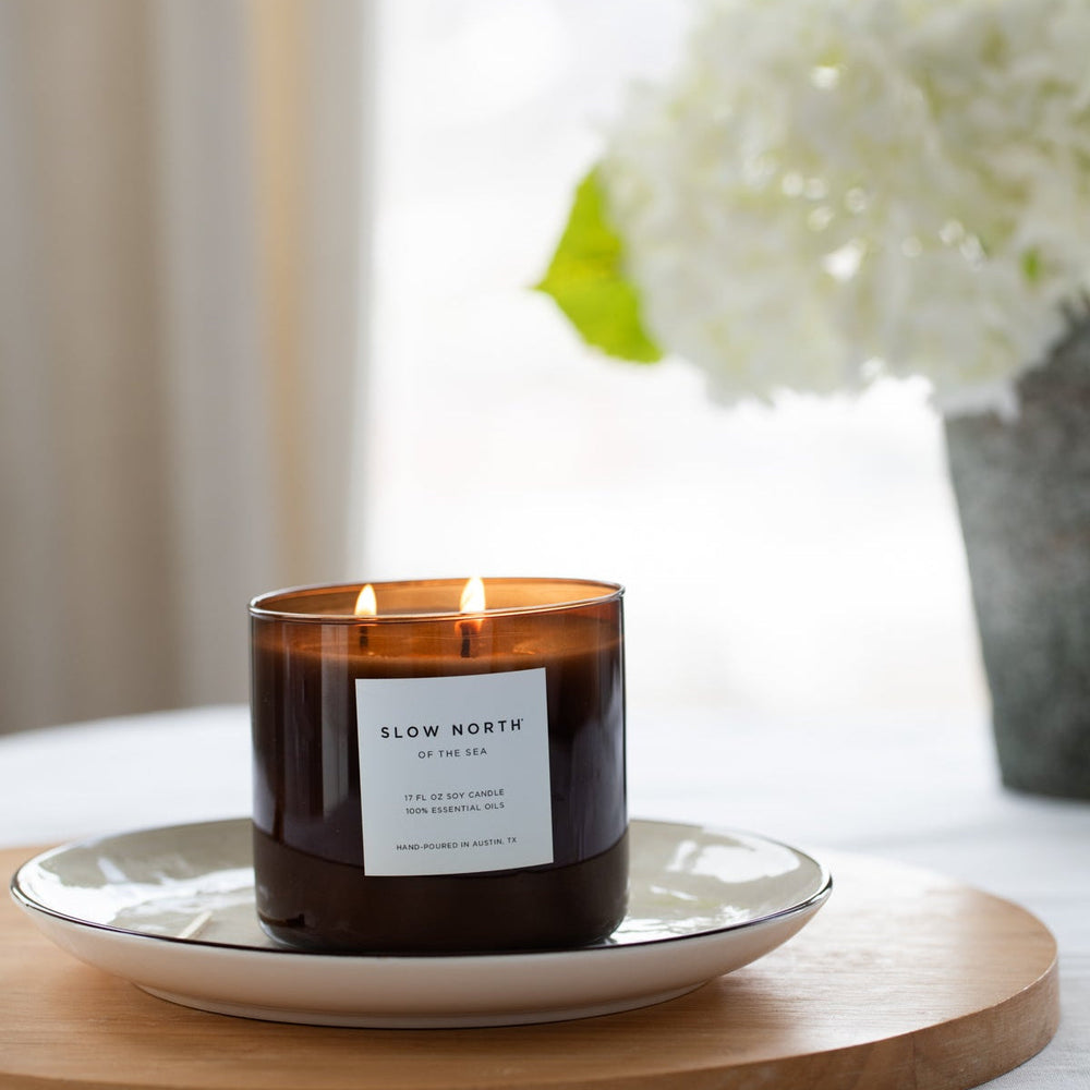 Of The Sea three-wick candle with ocean-inspired label and natural wax.