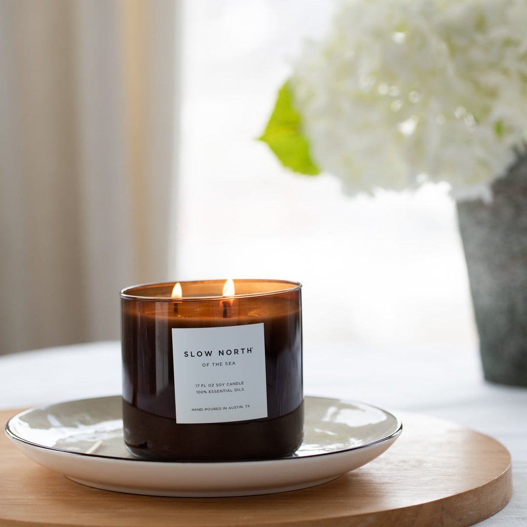 Of The Sea three-wick candle with ocean-inspired label and natural wax.