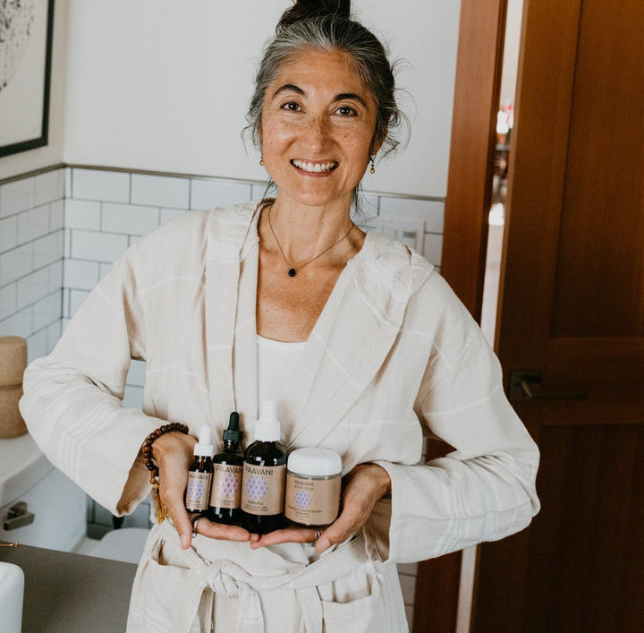 Tridoshic Ayurvedic skincare ritual set with herbal bottles, jars, and products.